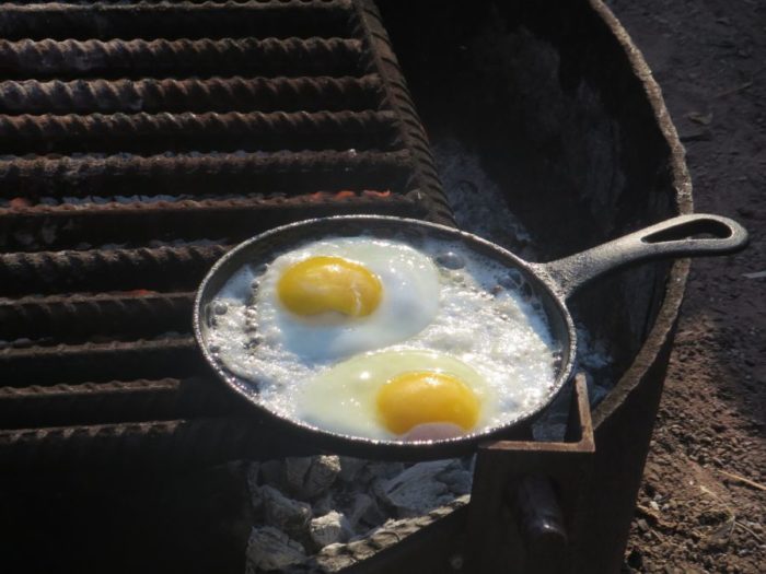 Two fresh eggs on a camp fire.