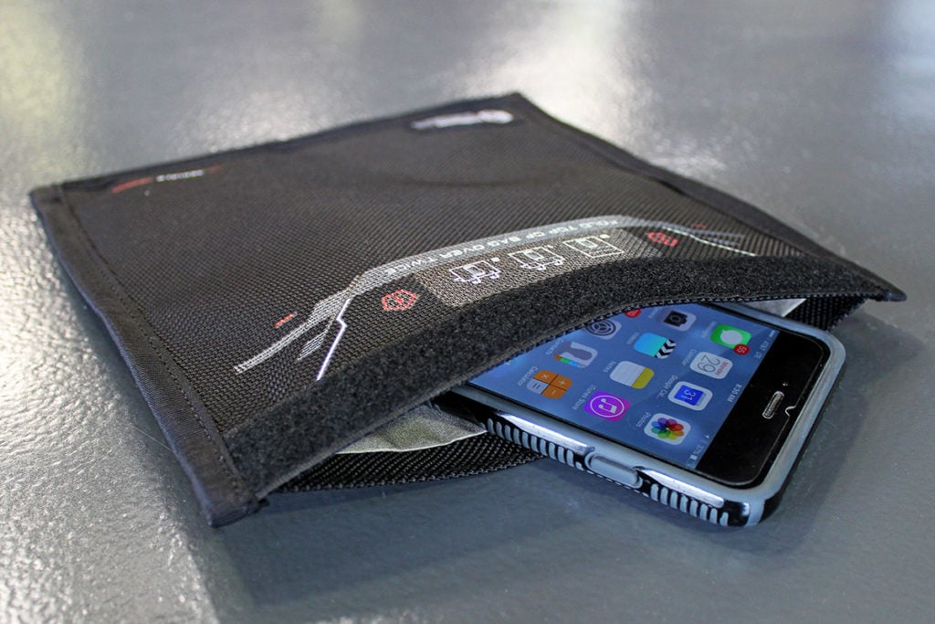 A cell phone, along with its battery, being kept safely in a Faraday bag.