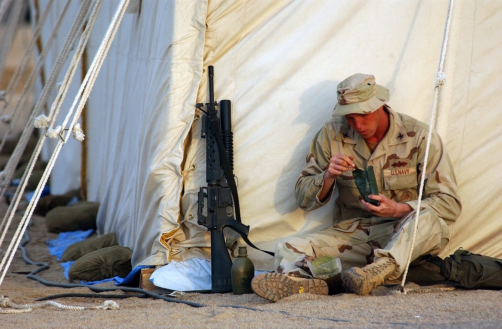 U.S. Navy service member eating an MRE while deployed.