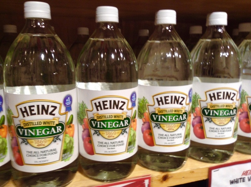 Bottles of vinegar lined up on a shelf.
